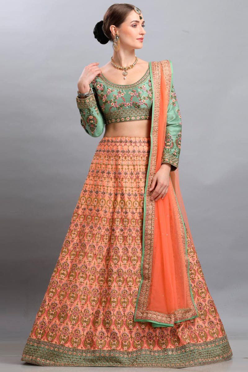 Photo of Bride in bright peach lehenga with green necklace